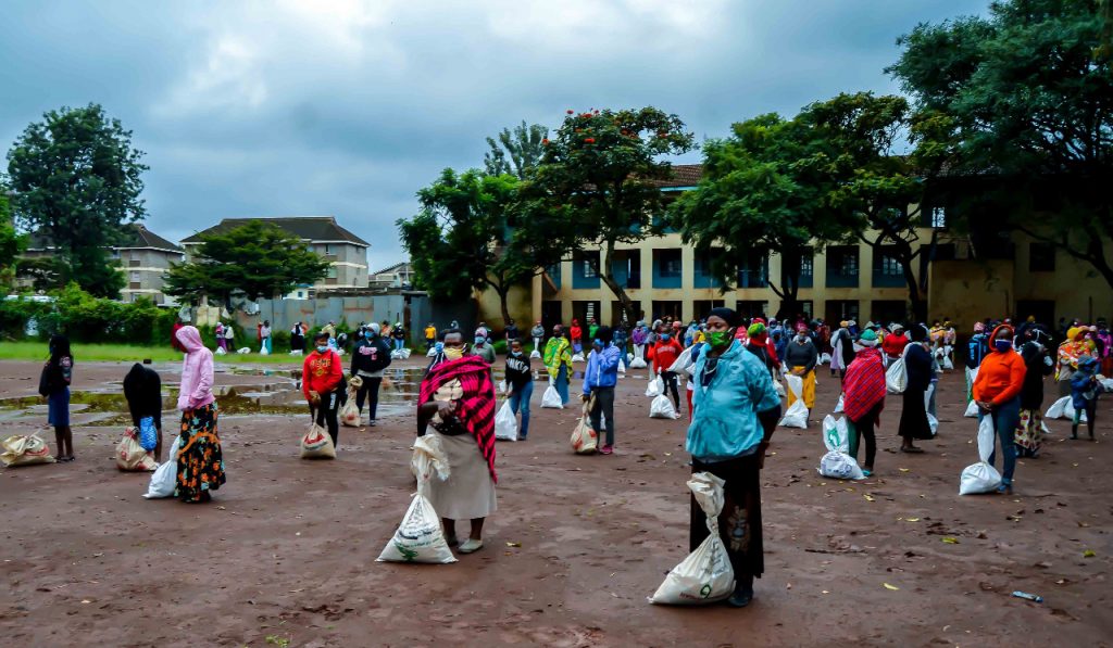 Community members collecting food parcels at an outdoor Simba Foundation distribution