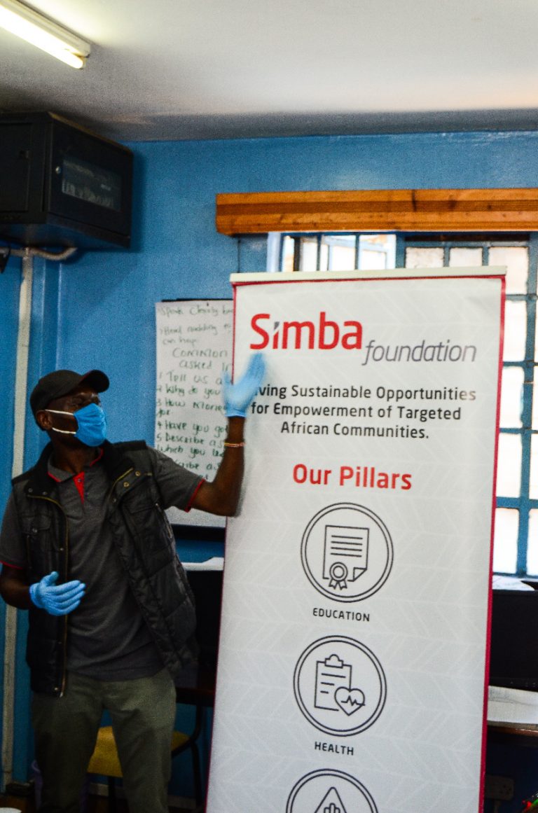 A Simba Foundation banner listing its pillars at a community session