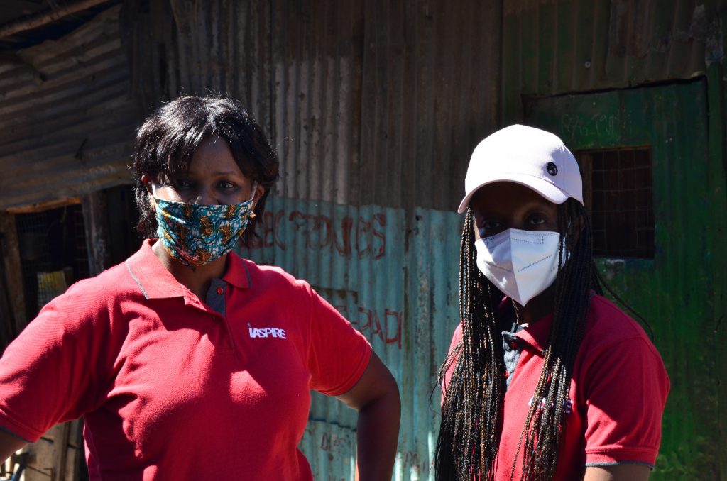 Two Simba Foundation volunteers in red shirts at a community visit